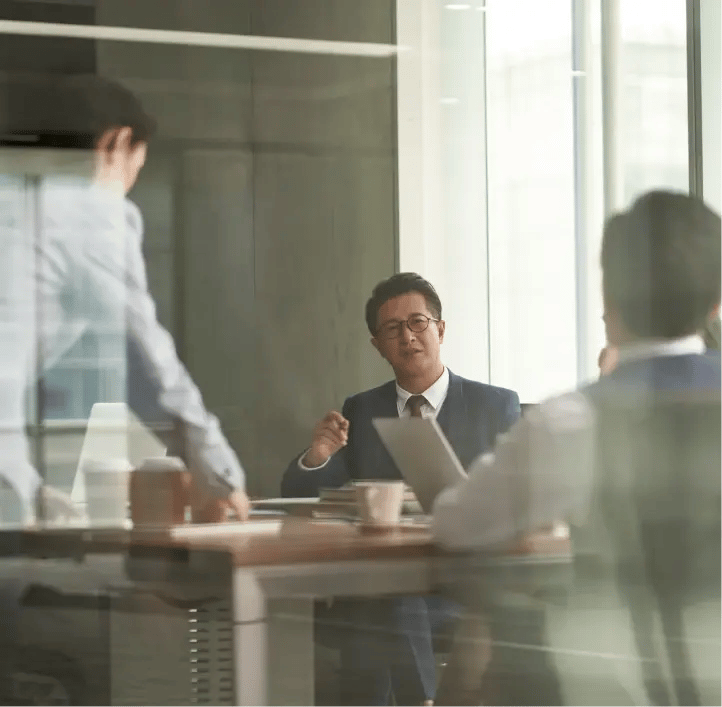 Business meeting in a glass-walled room.